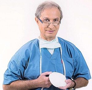 il medico tiene la protesi per l'aumento del seno